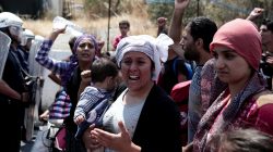 FILE PHOTO: Refugees and migrants from the camp of Moria shout slogans in front of riot police during a protest over the camp's conditions, near the city of Mytilene, on the Greek island of Lesbos, May 26, 2018. REUTERS/Elias Marcou/File Photo