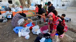 Migrants wash their clothes and fill bottles with water at a makeshift camp next to the Moria camp for refugees and migrants on the island of Lesbos, Greece, September 18, 2018. REUTERS/Giorgos Moutafis