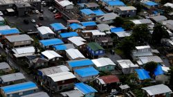 Plastic tarps over damaged roofs are seen on houses a year after Hurricane Maria devastated Puerto Rico in San Juan, Puerto Rico, September 18, 2018. Picture taken September 18, 2018. REUTERS/Carlos Barria