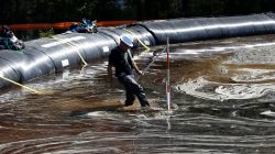 Santee Cooper worker Carl McCrea checks the water levels around a 6000 foot long Aqua Dam built to keep sediment from a coal ash retention pond from going into the flooded Waccamaw River in the aftermath of Hurricane Florence in Conway, South Carolina, U.S. September 26, 2018. REUTERS/Randall Hill