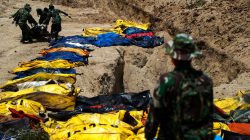 Soldiers move dead bodies of the victims of the earthquake and tsunami during a mass burial at the Poboya Cemetery in Palu, Central Sulawesi, Indonesia, October 2, 2018. REUTERS/Athit Perawongmetha