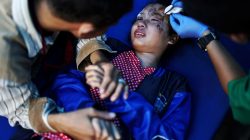 A father holds his daughter's hand in a hospital as she receives medical treatment for injuries sustained from the earthquake and tsunami in Palu, Central Sulawesi, Indonesia, October 4, 2018. REUTERS/Athit Perawongmetha