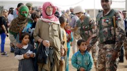 FILE PHOTO: Syrian refugees wait to board a Jordanian army vehicle after crossing into Jordanian territory with their families, in Al Ruqban border area, near the northeastern Jordanian border with Syria, and Iraq, near the town of Ruwaished, 240 km (149 miles) east of Amman September 10, 2015. REUTERS/Muhammad Hamed/File Photo