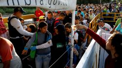 FILE PHOTO: Colombian migration officers check the identity documents of people trying to enter Colombia from Venezuela, at the Simon Bolivar International bridge in Villa del Rosario, Colombia August 25, 2018. REUTERS/Carlos Garcia Rawlins