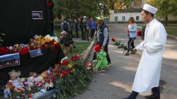 People place flowers and candles at a makeshift memorial near the scene of a recent attack on a local college in the city of Kerch, Crimea October 18, 2018. REUTERS/Pavel Rebrov