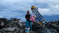 A woman holds a stuffed rabbit toy after it was found at her destroyed house where she said she had lost her three children after the area was hit by an earthquake, in Palu, Central Sulawesi, Indonesia, October 7, 2018. REUTERS/Jorge Silva/File photo