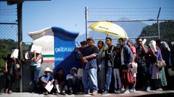 Central American migrants queue at a border connecting Guatemala and Mexico while waiting to cross into Mexico, in Talisman, Mexico October 23, 2018. REUTERS/Ueslei Marcelino