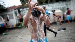 Migrants, part of a caravan of thousands from Central America en route to the United States, take a shower in the Mapastepec city center, Mexico October 24, 2018. REUTERS/Ueslei Marcelino