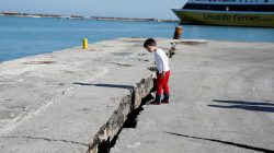 A child looks at the damaged pier of the port of Zakynthos, following an earthquake off the Zakynthos Island, Greece, October 26, 2018. REUTERS/Costas Baltas