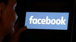 FILE PHOTO: A woman looks at the Facebook logo on an iPad in this photo illustration taken June 3, 2018. REUTERS/Regis Duvignau/Illustration/File Photo