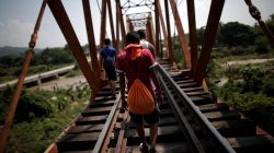 Migrants, part of a caravan of thousands from Central America en route to the U.S., walk on the train tracks, in Arriaga, Mexico October 26, 2018. REUTERS/Ueslei Marcelino