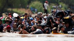 Central American migrants walk through the Suchiate river, the natural border between Guatemala and Mexico, in their bid to reach the U.S., as seen from Tecun Uman, Guatemala October 29, 2018. REUTERS/Carlos Garcia Rawlins