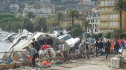 People help to remove debris around destroyed yachts on the shore after windstorm and the strong sea storm in Rapallo, Italy, October 30, 2018. Reuters/Massimo Pinca