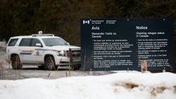 A Royal Canadian Mounted Police (RCMP) vehicle is seen near a sign at the US-Canada border in Lacolle, Quebec, Canada, February 14, 2018. REUTERS/Chris Wattie/File Photo