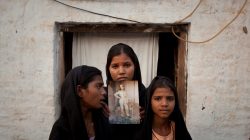 FILE PHOTO: The daughters of Pakistani Christian woman Asia Bibi pose with an image of their mother while standing outside their residence in Sheikhupura located in Pakistan's Punjab Province November 13, 2010. REUTERS/Adrees Latif/File Photo