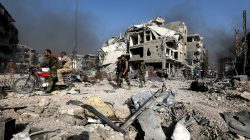 FILE PHOTO: Syrian army soldiers ride on a motorbike through rubble in al-Hajar al-Aswad, Syria May 21, 2018. REUTERS/Omar Sanadiki/File Photo